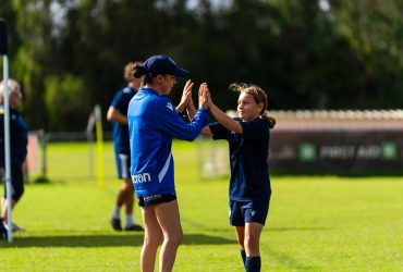 Coach high-fiving young player at Premier Invitational Mini’s tournament